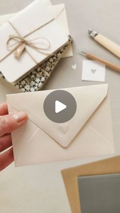 a person holding an envelope with a bow on it