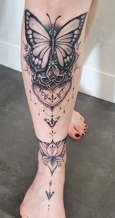 a woman's leg with a butterfly tattoo on it, and an intricate design