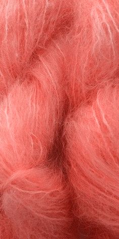 a close up view of a pink colored wool roving with lots of white yarn on top