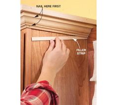 a person measuring the width of a cabinet door