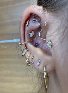 a woman with multiple ear piercings on her left side and one behind the ear