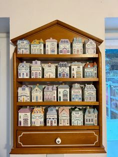 a wooden shelf filled with lots of small houses on top of it's sides