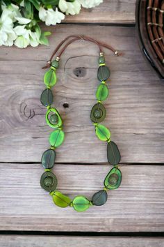 The Trinity necklace is a natural beauty. This long and lightweight necklace features an artful collection of seeds in different shapes and  in different shades of green: olive green, pear green and and pine green. This stunning necklace is the perfect addition to highlight solids and prints. Pair it with our tagua earrings to complete the look.  Thanks to the natural characteristics you can be sure yours is unique. Tagua, also called the vegetable ivory is the seed of a palm tree that grows in the tropical rainforests of several South American countries including Colombia, and Ecuador. Green Nature-inspired Necklace, Green Beaded Necklace In Recycled Glass, Green Beaded Necklaces In Recycled Glass, Green Beaded Recycled Glass Necklace, Adjustable Green Beaded Necklace In Nature-inspired Style, Adjustable Green Beaded Necklace With Nature-inspired Style, Green Recycled Glass Necklaces For Jewelry Making, Adjustable Nature-inspired Necklaces With Natural Variations, Adjustable Green Nature-inspired Beaded Necklace