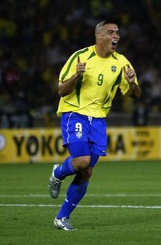 a soccer player is running on the field with his mouth open and fist in the air