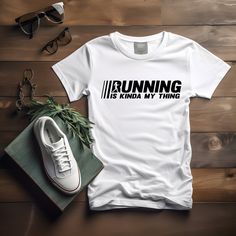 Introducing our "Running Is Kinda My Thing" shirt--perfect for anyone who loves to run and enjoys a good laugh. This vintage-style tee is an ideal gift for runners and marathon enthusiasts alike. With its playful puns and sarcastic one-liners, it's designed to bring a smile to the faces of friends, family, and fellow runners. Whether you're shopping for a birthday, Christmas, Mother's Day, or Father's Day, this shirt makes a fantastic gag gift. It's perfect for moms, dads, sisters, brothers, gra White Graphic Print T-shirt For Running, White Letter Print Top For Running, Casual Running T-shirt With Letter Print, Sarcastic One Liners, Gift For Runners, Run Shirt, Running Gift, Dry Humor, Fitness Shirt