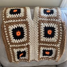 a crocheted blanket sitting on top of a couch