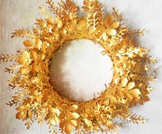 a wreath made out of gold leaves on a table