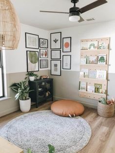 a living room with pictures on the wall and a round rug in front of it