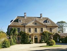 a large house with many windows and lots of greenery