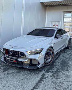 a silver sports car parked in front of a building