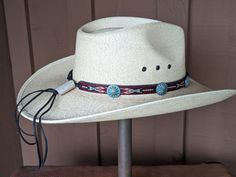 This hitched webbing hatband has a black leather base that is 15mm wide. Copper patina southwest style Conchos accent the band. Ties on with the deertan lace, slide the deer antler bead bead up to "tighten and tie 2 knots in the lace to secure the band. 23" long. Looks great on both palm and felt hats. Hat not included. Luxury Western Hat Bands With Curved Brim, Rustic Adjustable Handmade Hat Bands, Traditional Adjustable Hat For Outdoor, Adjustable Western Hat Bands For Themed Events, Artisan Adjustable Hat Bands For Outdoor, Adjustable Artisan Hat Bands For Ranch, Traditional Adjustable Hat For Country Events, Adjustable Western Hat Bands For Western-themed Events, Adjustable Western Concho Hat Bands