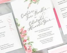 the wedding stationery is laid out on top of each other, with pink flowers and greenery