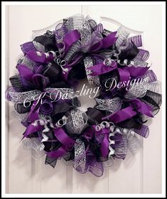 a purple and black mesh wreath hanging on a door