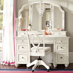 a white vanity with mirror, stool and chair in front of the dresser is shown