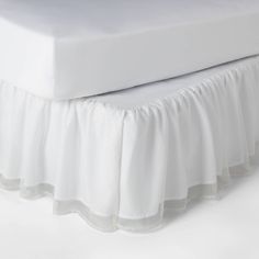 a white bed skirt with ruffled edges