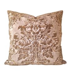 a brown and gold pillow with an ornate design on the front, sitting on a white background