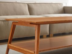 a wooden table sitting on top of a carpeted floor in front of a couch