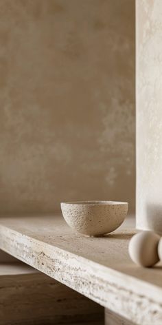 a white bowl sitting on top of a wooden table next to two eggs and an egg holder