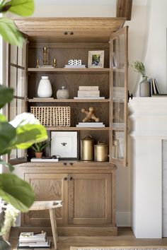 a living room with a fireplace and wooden shelves filled with books, vases and other items