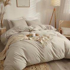 an unmade bed in a white bedroom with pillows and blankets on top of it