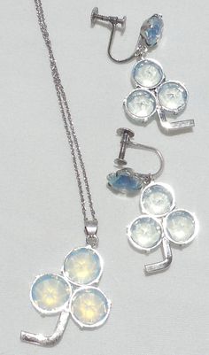 "This pretty vintage opalite (a.k.a. opaline & moonstone glass) set has a pendant necklace and a pair of dangle earrings in a unique shamrock design. The two pieces are obviously matching, but only the earrings are marked. Another thing to note is the larger glass stones in the pendant are just slightly more opalescent than the stones in the earrings. Because the earrings are less opalescent than the pendant, they sparkle more, so they look more like crystal. This is insignificant but mentio Vintage Moonstone Jewelry Collectible, Vintage Opal Gemstone Jewelry, Handmade Vintage Opal Jewelry, Shamrock Design, Mystic Topaz, Silver Filigree, Heart Pendant Necklace, Necklace Earring Set, Glass Set