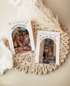 two personalized photo cards sitting on top of a doily next to a white blanket