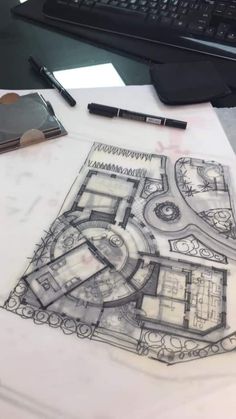 a drawing of a building on top of a table next to a keyboard and pen