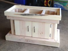 an unfinished wooden cabinet with drawers on the bottom and doors open to show what's inside