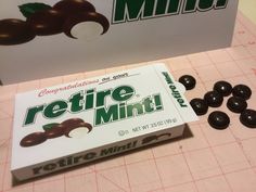 a box of retro mints sitting on top of a cutting board next to some chocolate candies