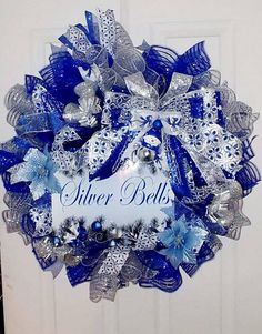 a blue and silver christmas wreath hanging on a door