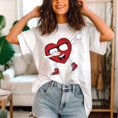 a woman wearing shorts and a t - shirt with a cartoon heart on the front