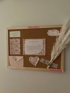 a cork board with some writing on it and a white feather sticking out of it