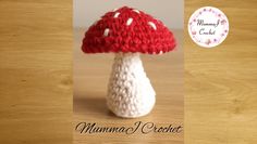 a crocheted mushroom sitting on top of a wooden table next to a sticker