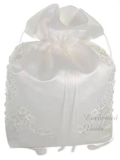 a white satin bag with an embroidered flower on it