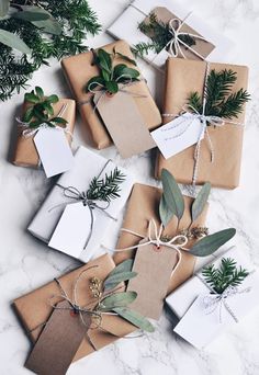 christmas presents wrapped in brown paper and tied with twine, greenery and tags