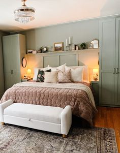 a bedroom with a bed, dressers and a chandelier in the corner