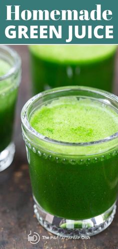 two glasses filled with green juice on top of a table