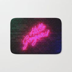 a neon sign that says hello gorgeous on a brick wall