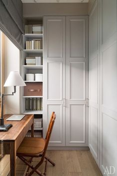 a chair sitting in front of a desk next to a book shelf