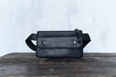 Introducing our stylish Unisex Leather Waist Bag - the perfect blend of convenience and fashion in a compact design. This small crossbody bag, also known as a fanny pack or belt bag, is the ultimate accessory for those who value functionality and style. Designed to keep your essentials close at hand, this sling bag comfortably sits on your waist, leaving you hands-free to enjoy your activities without worry. As a versatile accessory, this waist bag can also be used as a women's wallet or a small leather purse, accommodating your phone, cards, and cash in a neat and organized manner. The phone wallet feature ensures your mobile device is securely stored while being easily accessible for quick use. With its adjustable belt, this crossbody bag caters to all waist sizes, providing a comfortabl Casual Rectangular Belt Bag Ideal For Gifts, Casual Rectangular Belt Bag As Gift, Casual Rectangular Belt Bag Perfect For Gifts, Casual Crossbody Belt Bag As Gift, Black Pouch Belt Bag As Gift, Small Leather Purse, Leather Waist Bag, Small Crossbody, Adjustable Belt