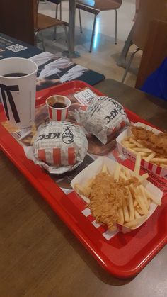 a tray that has some food on it and a cup in front of the tray