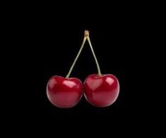 two cherries hanging on a black background