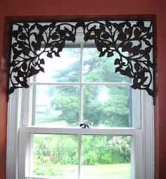 the window is decorated with black leaves and has a white valance on it's side