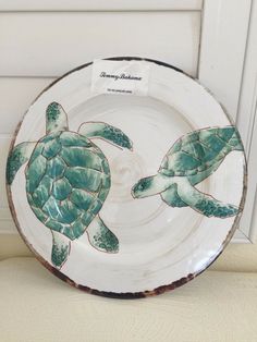 a white plate with green sea turtles painted on it's sides and the bottom