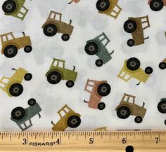 a ruler is next to a fabric with trucks on it