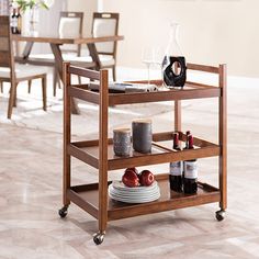 a kitchen cart with wine bottles, plates and glasses on it in front of a dining room table