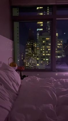 a bedroom with a view of the city at night