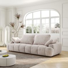 a modern living room with white walls and wood flooring is furnished with beige furniture