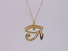 The Eye of Horus necklace is a mystifying piece of jewellery. The necklace features a pendant that is crafted in the shape of the Eye of Horus, an ancient Egyptian symbol of protection, power, and good health. The pendant is made of 22k gold vermeil and has a high polish finish, giving it a luxurious and radiant appearance. The Eye of Horus is intricately designed with fine curving details to create a subtle dramatic effect. At the center of the Eye of Horus pupil is a brilliant 2.3mm sapphire, which captivatingly brings the piece alive. It is carefully selected for its quality and is set in a secure and elegant bezel setting. The pendant measures approximately 2cm x 2cm and hangs on a delicate chain that complements the design and adds a touch of divine femininity to the piece. The chain Symbolic Ceremonial Necklace With Locket, Symbolic Ceremonial Locket Necklace, Symbolic Locket Necklace For Ceremonial Use, Gold Amulet Charm Necklace With Large Pendant, Symbolic Gold Jewelry With Large Pendant, Symbolic Gold Plated Necklaces With Large Pendant, Gold Necklaces With Large Symbolic Pendant, Symbolic Handmade Gold Plated Necklaces, Handmade Ankh Gold Necklace