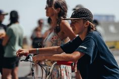 a young boy riding a bike next to other people